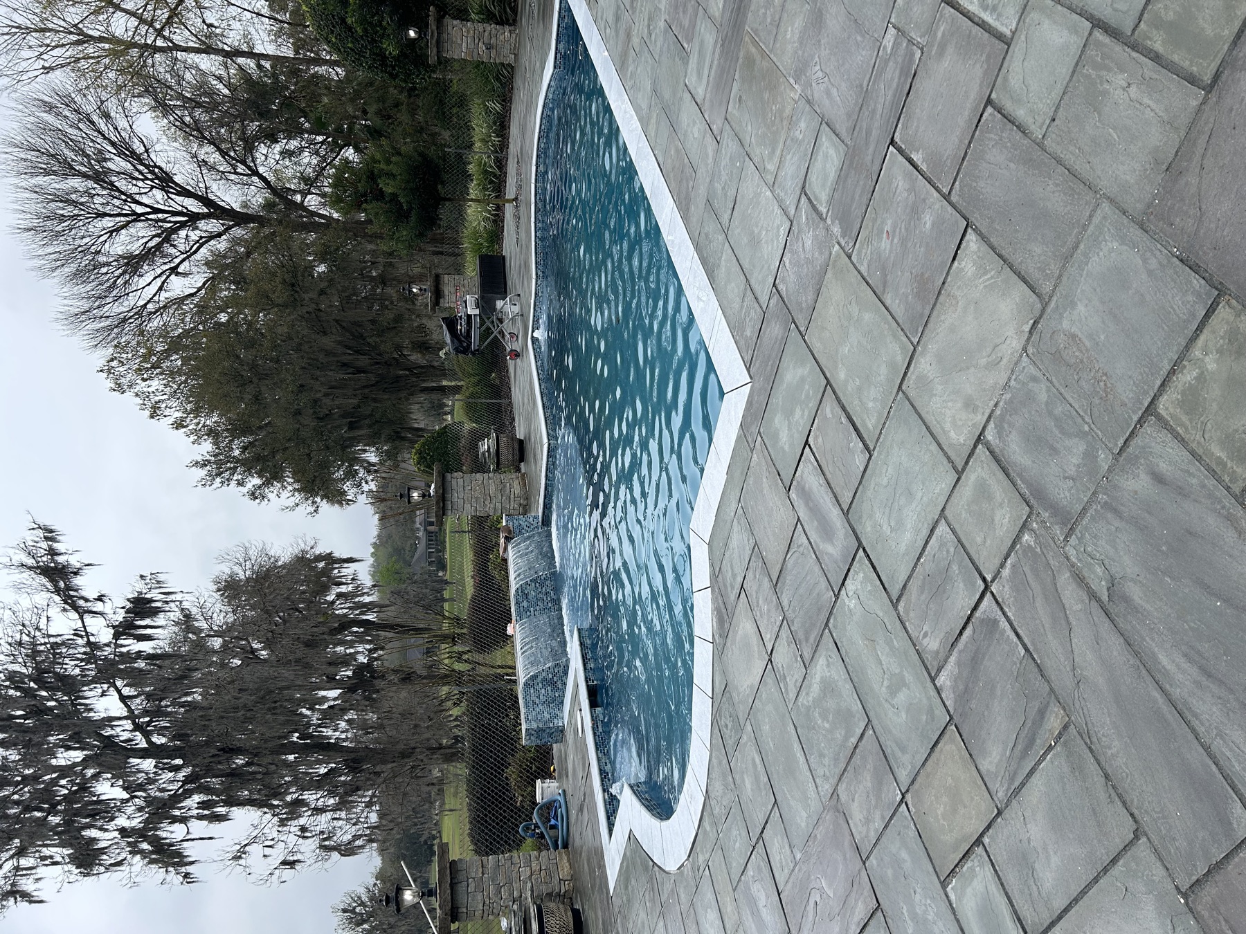 Finished Koah pool with twin waterfalls and gray paver deck