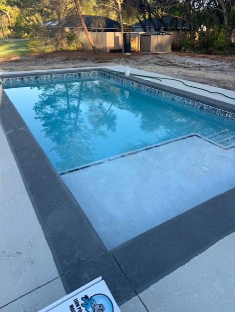 Finished Koah pool with waterline tile, sun shelf, and clean deck edge
